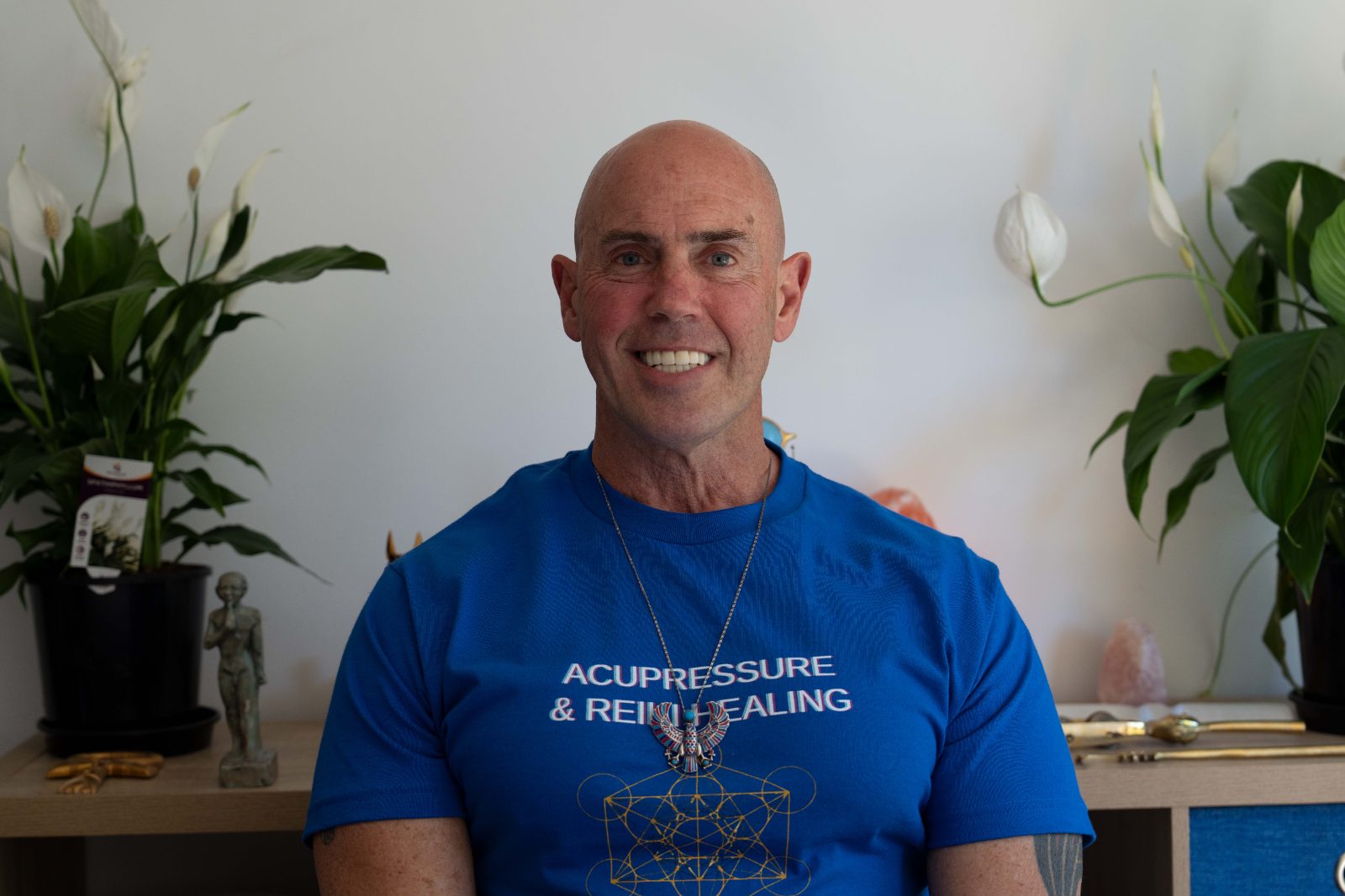Steve Harmon smiling, wearing an Acupressure & Reiki Healing t-shirt